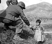 Soldier helping Korean child